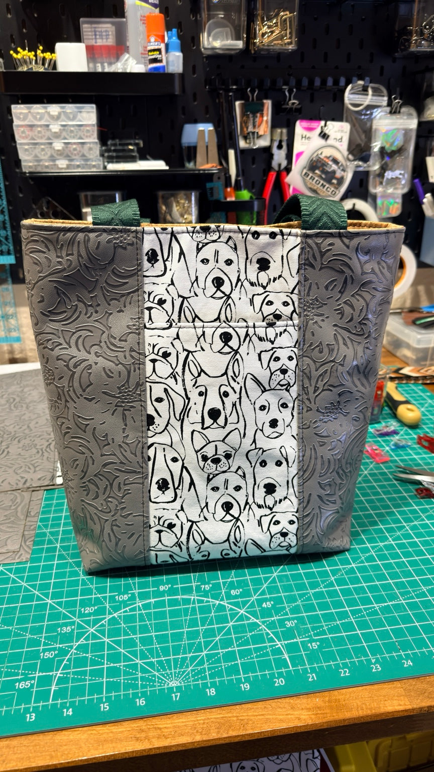 Front view of handmade dog-print tote bag with gray embossed panels, black-and-white dog illustrations and forest green handles