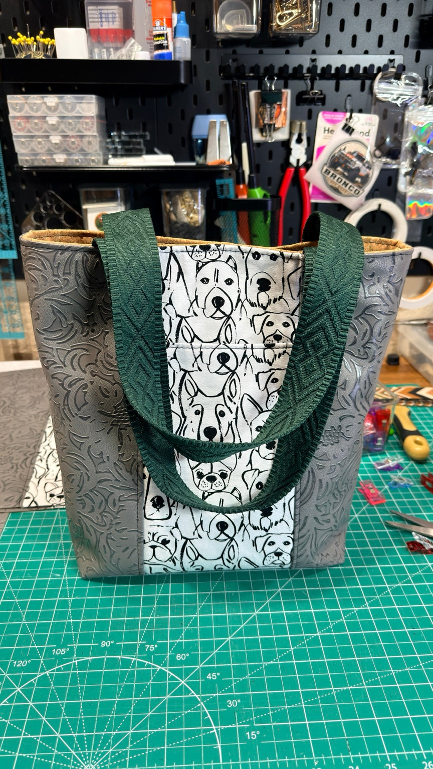 Dog-print tote bag with long textured forest green carrying handles and gray embossed side panels
