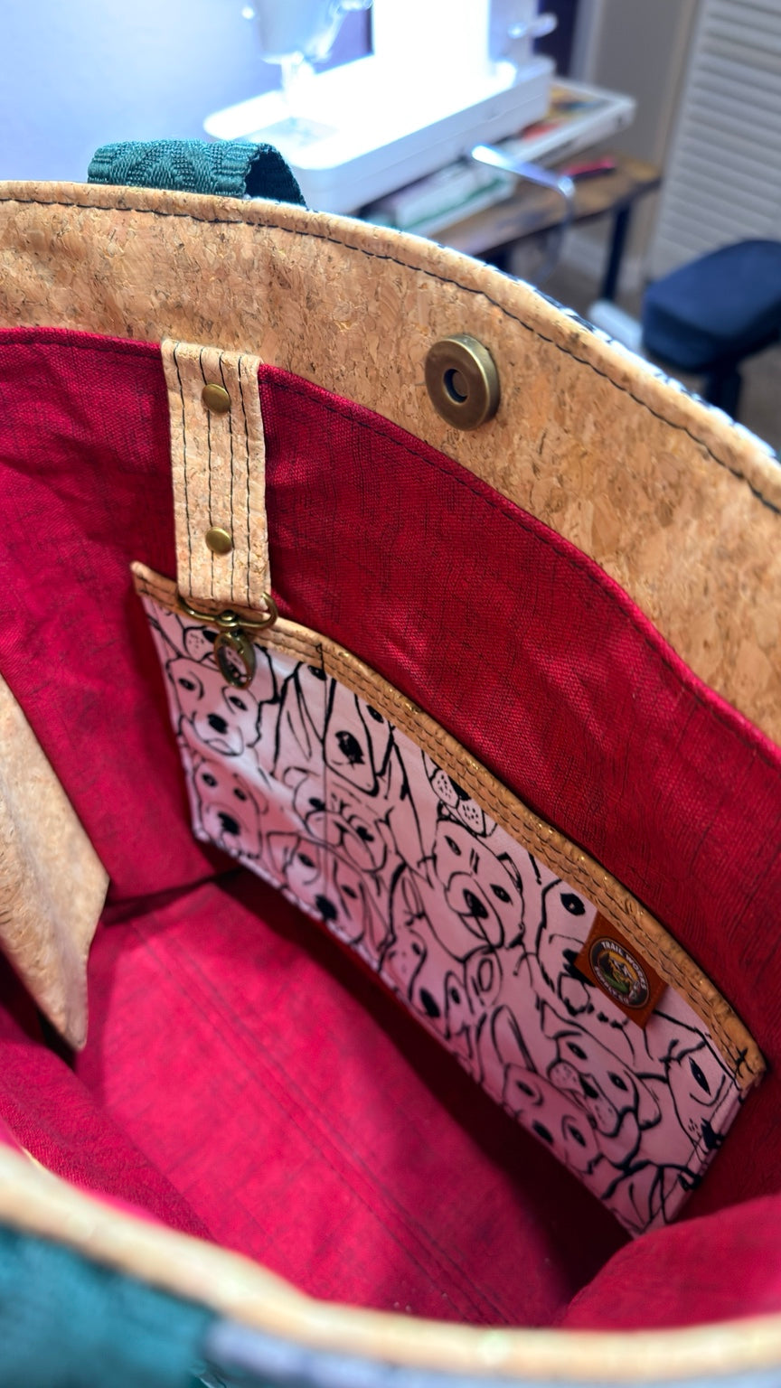 Close-up inside dog-print tote of the dog-pattern slip pouch with cork accents and brass snap hardware